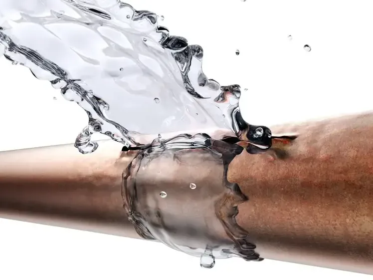 Water spraying from a split copper pipe