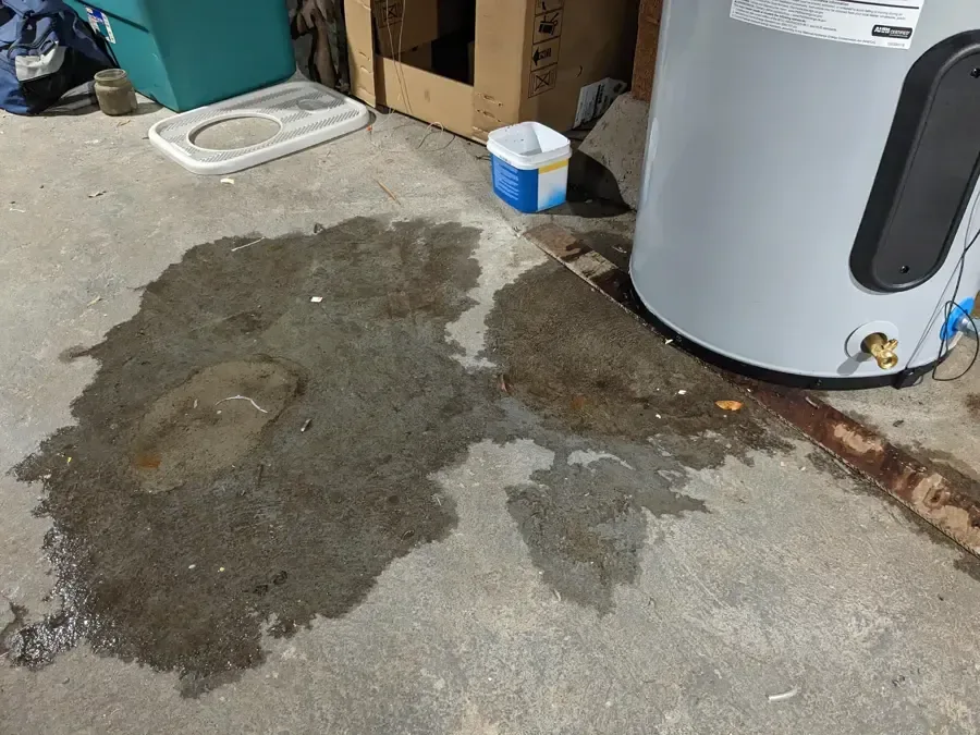 Water pooled on a concrete floor beside a water heater